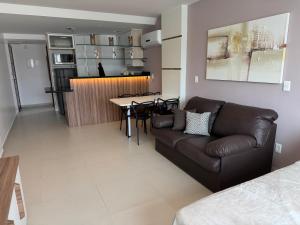 a living room with a couch and a table at Loft Com Vista Para O Mar in Arraial do Cabo