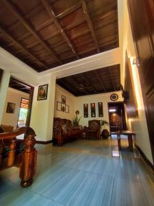 ein großes Wohnzimmer mit Couch und Tisch in der Unterkunft Periyaveettil Heritage in Neyyāttinkara