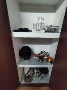 eine kleine Speisekammer mit einer Menge Sachen darin in der Unterkunft Periyaveettil Heritage in Neyyāttinkara