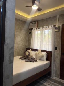 Un dormitorio con una cama con ventilador de techo. en Solana Inn El Nido, en El Nido