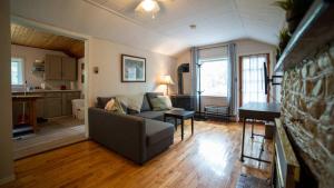 een woonkamer met een bank en een keuken bij 3-Bedroom Cottage #1 Hamilton in Sharbot Lake