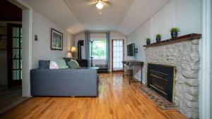 een woonkamer met een bank en een open haard bij 3-Bedroom Cottage #1 Hamilton in Sharbot Lake
