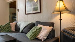 een woonkamer met een bank met kussens en een lamp bij 3-Bedroom Cottage #1 Hamilton in Sharbot Lake +46 foto's