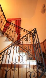 a spiral staircase in a bedroom with a red curtain at Albergo Panorama in Frascati