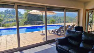 ein Wohnzimmer mit Poolblick in der Unterkunft Quintela Village by Gerês Casas in Terras de Bouro