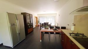 eine Küche mit einem Kühlschrank und einem Tisch mit Stühlen in der Unterkunft Quintela Village by Gerês Casas in Terras de Bouro