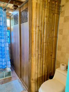 a bathroom with a toilet and a bamboo wall at Chalet de Bambú Urku Wasi in Otavalo