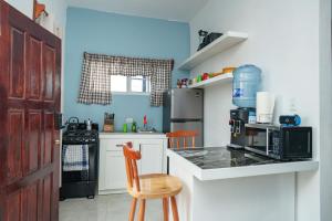 a kitchen with blue walls and a counter with a chair at Casa De Shangrila in Belize City