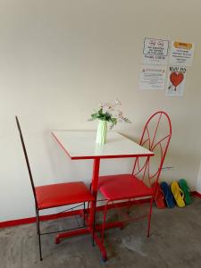 a table with two chairs and a vase with flowers at WJV INN CASUNTINGAN in Mandaue City +24 photos
