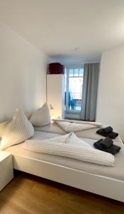 a large bed with white sheets and pillows on it at Ferienwohnung De Krabb in Dorum +4 photos