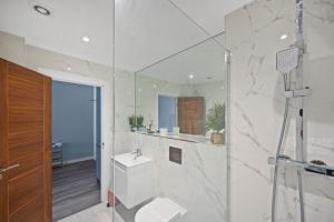 Un baño blanco con inodoro y ducha. en Marvel House, en Milton Keynes 16 fotos más