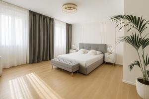 a white bedroom with a bed and a potted plant at LB - Luna Luxury Suite in Bergamo
