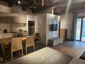 a kitchen with a wooden table and chairs and a counter at Dimore Pietrapenta Apartments, Suites & Rooms - Via Lucana 223, Via Piave 23, Via Chiancalata 16, Vico Fornaci 9 in Matera