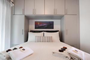 a bedroom with a white bed with towels on it at Melodia Lefkada apartment 5 in Nikiana