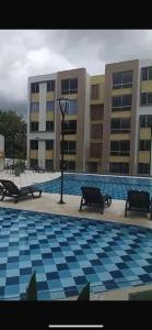 a large building with a pool with benches in front at Acogedor apartamento en Ibagué 201 in Ibagué
