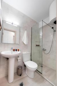 a bathroom with a toilet and a sink and a shower at Melodia Lefkada apartment 5 in Nikiana +9 photos