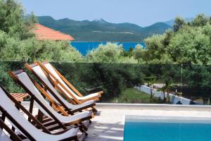 a group of chairs sitting next to a swimming pool at Melodia Lefkada apartment 5 in Nikiana