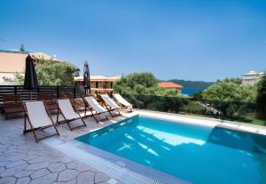 a pool with chaise lounge chairs and a swimming pool at Melodia Lefkada apartment 5 in Nikiana