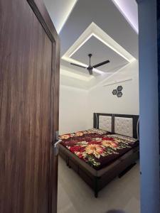 Un dormitorio con una cama y un ventilador de techo. en Your second home, en Patiala
