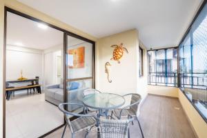 a dining room with a glass table and chairs at Apto 2 quartos c vista pro parque na Praia JSM0103 in Salvador