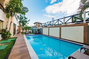 a swimming pool in the backyard of a house with a building at Apto 2 quartos c vista pro parque na Praia JSM0103 in Salvador