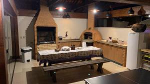 a large kitchen with a table and an oven at Casa Campos do Jordão, bairro Capivari, Wi-Fi, churrasqueira e forno de pizza, totalmente equipada in Campos do Jordão