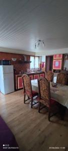 a kitchen with a table and chairs and a kitchen with a refrigerator at jolie appartement en rez de chaussée in Quillan