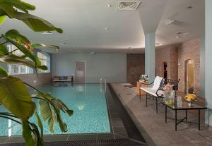 a swimming pool with a chair and a table in a building at Garden Suites with private Jacuzzi in Burgh Haamstede +19 photos