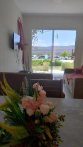 a vase of flowers on a table in a living room at Chalés Aconchego da Serra in Sairé
