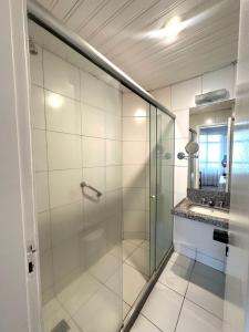ein Badezimmer mit Glasdusche und Waschbecken in der Unterkunft 1155 golden 55m2 1 quarto frente mar avenida beira mar in Fortaleza