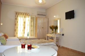 ein Hotelzimmer mit zwei Betten und einem Tisch mit Getränken in der Unterkunft Kalia Studios in Agia Anna