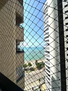 einen Blick durch einen Drahtzaun eines Gebäudes in der Unterkunft 1155 golden 55m2 1 quarto frente mar avenida beira mar in Fortaleza + 4 Fotos