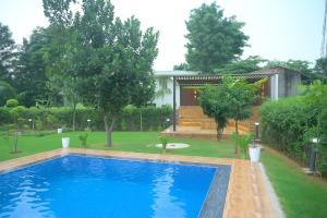 a swimming pool in the yard of a house at Aravali Farm Gurgaon, 3 Bedroom Villa with Lawn Barbeque Grill and Pool in Gurgaon