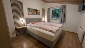 une chambre avec un lit dans une pièce avec une fenêtre dans l'établissement Appartement Ripper, à Saalbach-Hinterglemm