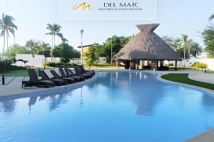 a pool at a resort with lounge chairs and a gazebo at Altamar in Nuevo Vallarta 