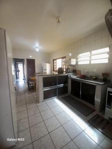 a kitchen with a counter top and a large kitchen at Casa de Praia in Ubatuba