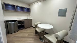 a small kitchen with a small table and chairs at Costa Mesa Inn - Newport Beach Area in Costa Mesa