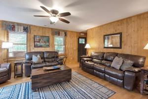 a living room with leather furniture and a ceiling fan at 30 Mins to Boone, Fire Pit, Hot Tub, 3 porches, Dogs OK in Brownwood