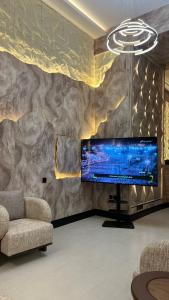 a living room with a large tv on a stone wall at الفؤاد العربي in Abha +53 photos