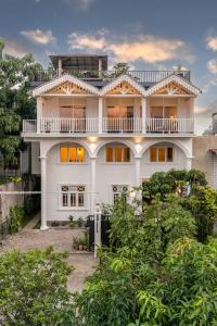 a white house with a balcony on top of it at COLOMBO Eco Lodge & Wellness Centre in Colombo