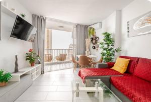 een woonkamer met een rode bank en een tafel bij Exclusive ocean front apartment in Playa de las Americas