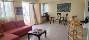 a living room with a red couch and a table at Los Tres Ojos Stay in Ensanche Savica de Mendoza +7 photos