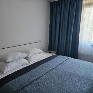 a bedroom with a bed with two pillows and a window at AC House Apartments in Sarajevo