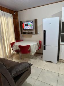 a living room with a table and a refrigerator at Casa grande 500mt de Mariscal beach in Bombinhas