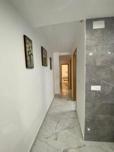 a hallway with white walls and a stone wall at ALLOUCHE Yahia in Torrevieja
