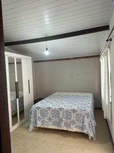 a bedroom with a bed in a room with a window at Casa grande 500mt de Mariscal beach in Bombinhas