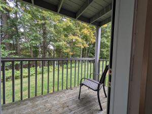 a porch with a bench sitting on a deck at Tremblant Hideaway, Ski & Golf Retreat in Mont-Tremblant