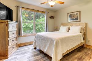 a bedroom with a bed and a dresser and a window at Murrayville Lakefront Cabin with Boat Slip and Grill! in Murrayville