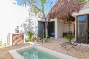 a villa with a swimming pool in front of a house at UTSKIN By ZENDA - Luxury Villas & Private Pools in Tulum
