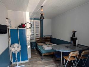 a small room with a table and a couch at Le nid douillet Industriel in La Bourboule